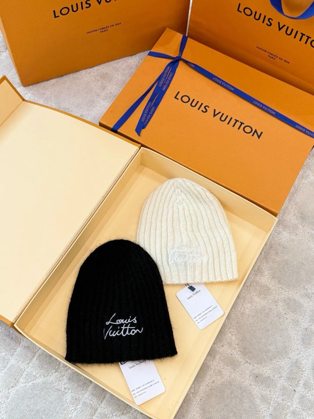 LOUIS VUITTON autumn and winter ski series cold hat ●Original version: purchased and developed for 4200 ●Item number: 1681972-A60 ●Fabric: wool blended fabric ●Technology: knitted ●Color: white/black ●Version: fitted version ●Description: Made of 100% Baby Cashmere (young cashmere), woven with a 28-needle worsted spinning process, the yarn fineness is 14.5 microns, and it feels light and soft. The main body of the hat has a vertical grooved texture, and is elastically wrapped using fixed-spacing stitching techniques to fit a head circumference of 56-58cm. The logo on the front of the hat adopts French satin embroidery technology, and the embroidery thread is made of high-gloss silk thread. The stitch density reaches 90 stitches/square centimeter. The font outline is smooth and not easy to fall off. The cap opening is ribbed with the same material, which has long-lasting elasticity and is not easy to loosen. The finished product is shaped by low-temperature steam to ensure that the hat shape is three-dimensional and crisp. The post-finishing process includes anti-pilling treatment, taking into account both luxurious texture and daily durability. The packaging comes with an exclusive dust bag, continuing the exquisite standards of the brand's high-end accessories. The overall wiring is straight and delicate, the fabric is comfortable and soft, and the color is consistent without color difference. It can be matched with the same style to create a fashionable look and control various occasions. Customized accessories, complete with three standards, same style for men and women!